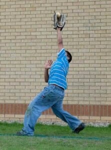 Little league player in drop step fly ball drill