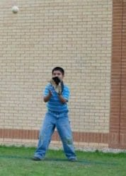 little league baseball player catching fly ball in practice